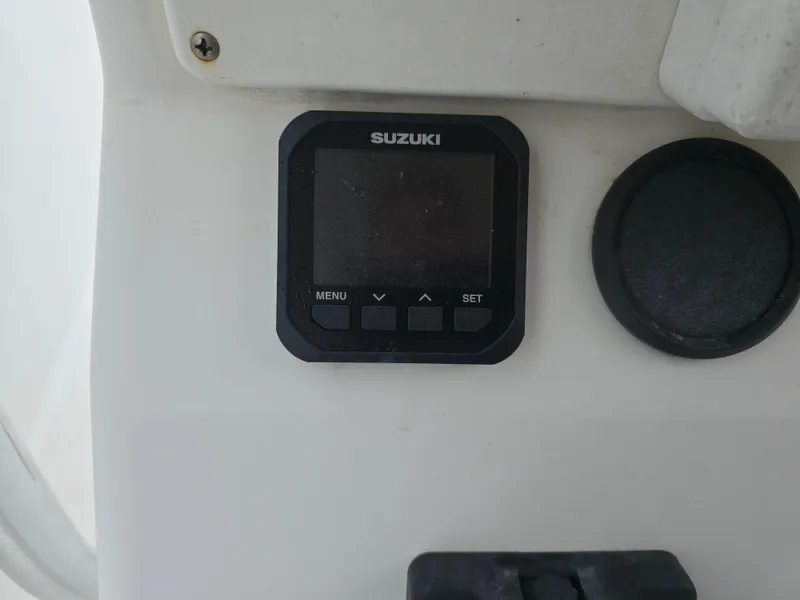 Slide: The Image of 2002 Edgewater 225CC boat with outboard motor, parked outdoors near houses. - 9