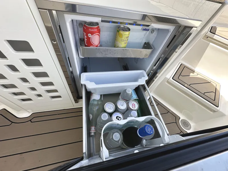 Slide: The Image of Built-in fridge on 2017 Sea Ray SLX 350 boat, stocked with beverages. - 13