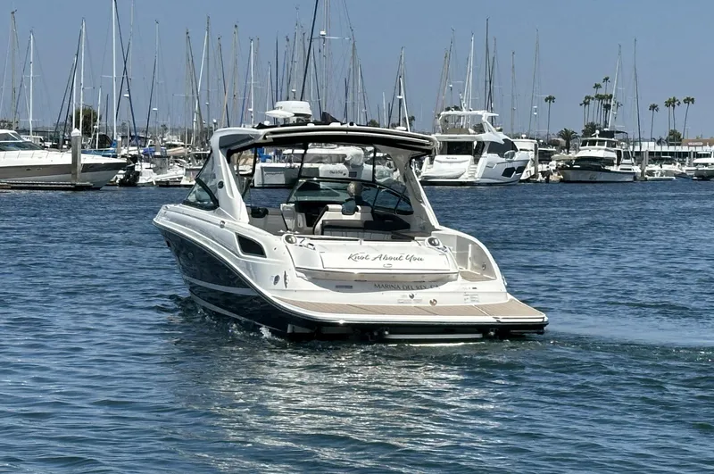 Slide: The Image of 2017 Sea Ray SLX 350 boat cruising in a marina with sailboats in the background. - 2