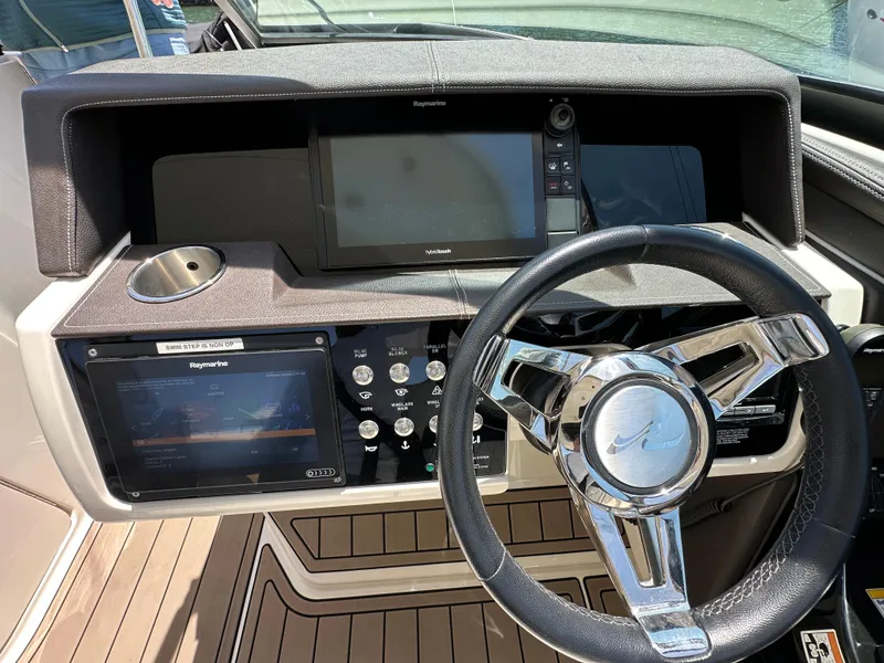 Slide: The Image of 2017 Sea Ray SLX 350 helm with steering wheel, navigation screens, and control panel. - 22