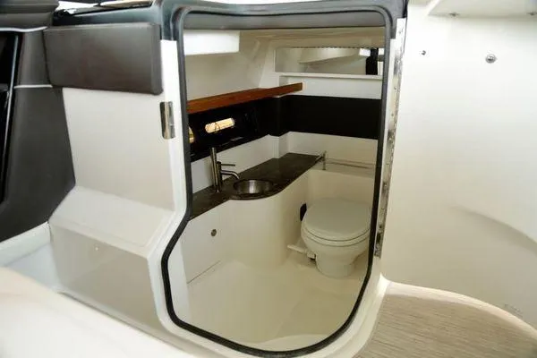 Slide: The Image of 2017 Sea Ray SLX 350 boat interior with compact bathroom, sink, and toilet. - 34