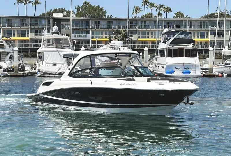 Slide: The Image of 2017 Sea Ray SLX 350 boat cruising in a marina with docked yachts. - 4
