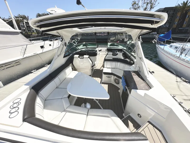 Slide: The Image of 2017 Sea Ray SLX 350 boat interior with luxurious seating and table, docked at marina. - 7
