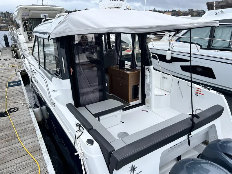 Slide: The Image of 2023 Jeanneau NC 895 boat docked, featuring a covered cockpit and modern design. - 8