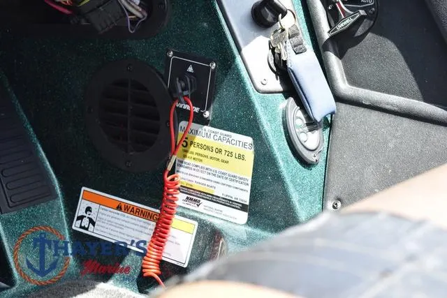 Slide: The Image of 2014 Ranger Z119c boat dashboard with capacity warning labels and controls. - 13