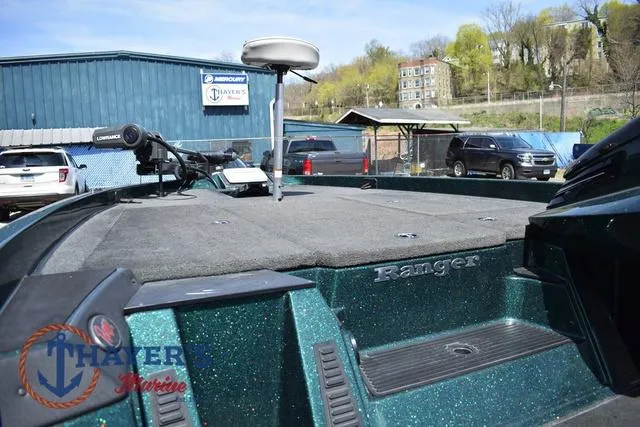 Slide: The Image of 2014 Ranger Z119c boat deck with fishing equipment, parked near Thayer's Marine building. - 19