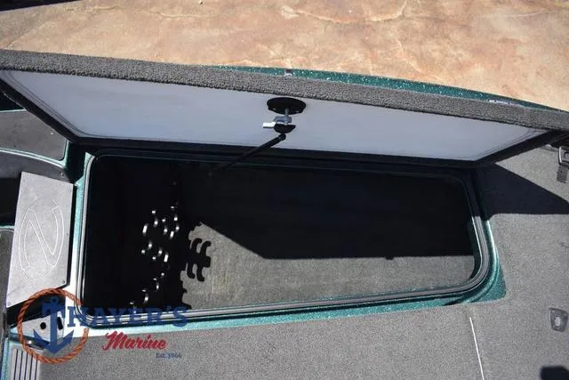 Slide: The Image of Open storage compartment in 2014 Ranger Z119c boat, featuring carpeted interior and latch mechanism. - 23