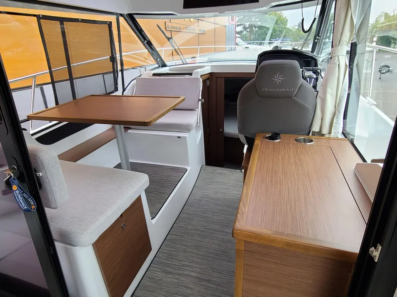 Slide: The Image of 2023 Jeanneau NC 895 interior with seating, table, and helm station. - 3