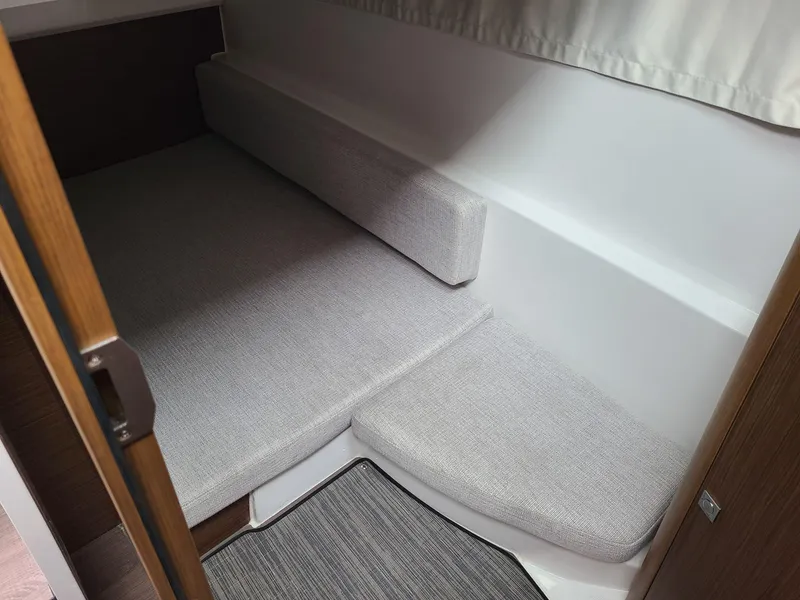 Slide: The Image of 2023 Jeanneau NC 895 cabin interior with gray cushions and wooden accents. - 6