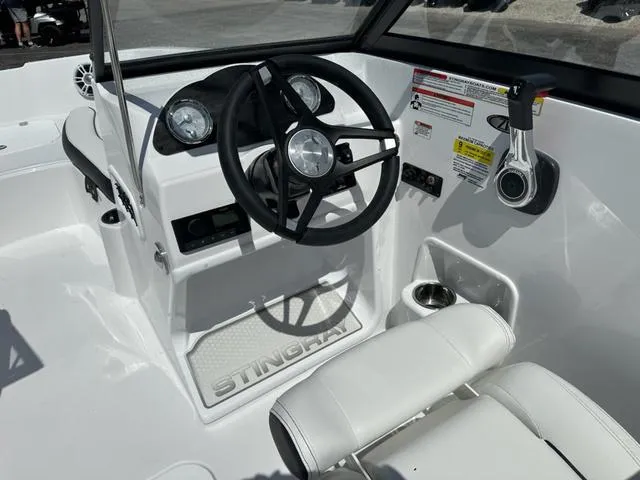 Slide: The Image of 2025 Stingray DC 191 boat cockpit with steering wheel and controls, featuring sleek white design. - 14