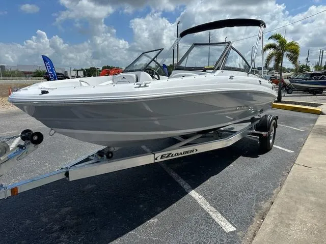 Slide: The Image of 2025 Stingray DC 191 boat on trailer, parked outdoors under a cloudy sky. - 5