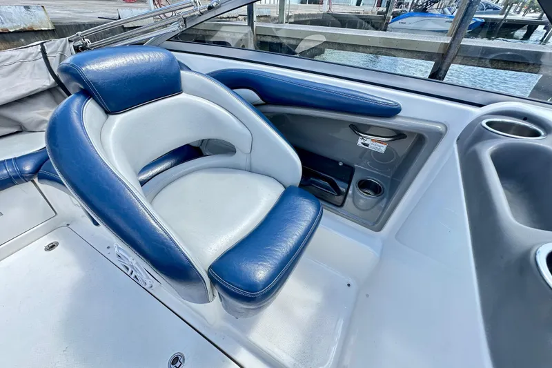 Slide: The Image of 2011 Yamaha Boats 242 Limited interior with blue and white seating near water. - 10