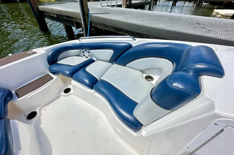 Slide: The Image of 2011 Yamaha Boats 242 Limited interior with blue and white seating near dock. - 14