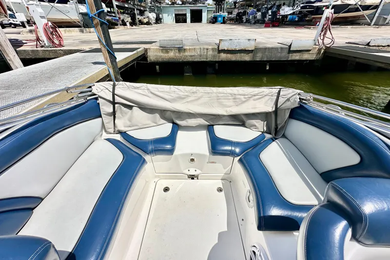 Slide: The Image of 2011 Yamaha Boats 242 Limited interior with blue and white seating at dock. - 19