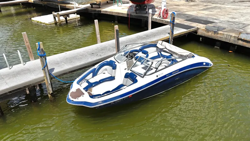 Slide: The Image of 2011 Yamaha Boats 242 Limited docked in marina, blue and white design. - 2