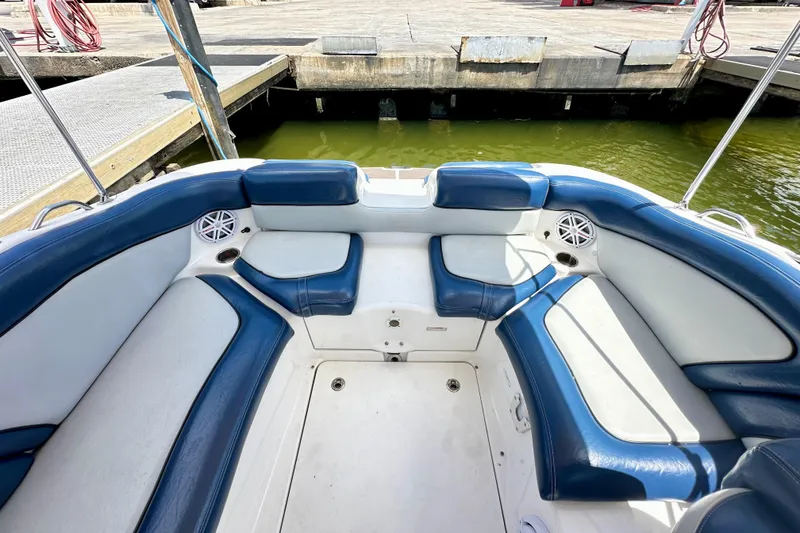 Slide: The Image of 2011 Yamaha Boats 242 Limited interior with blue and white seating, dockside view. - 21