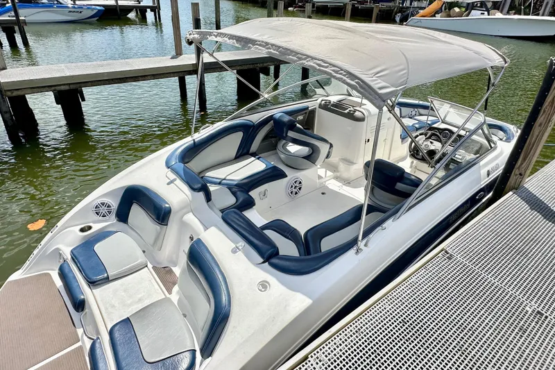 Slide: The Image of 2011 Yamaha Boats 242 Limited, docked, featuring spacious seating and canopy. - 24