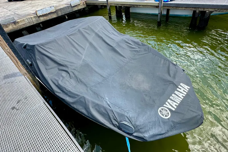 Slide: The Image of Covered 2011 Yamaha Boats 242 Limited docked on water. - 29