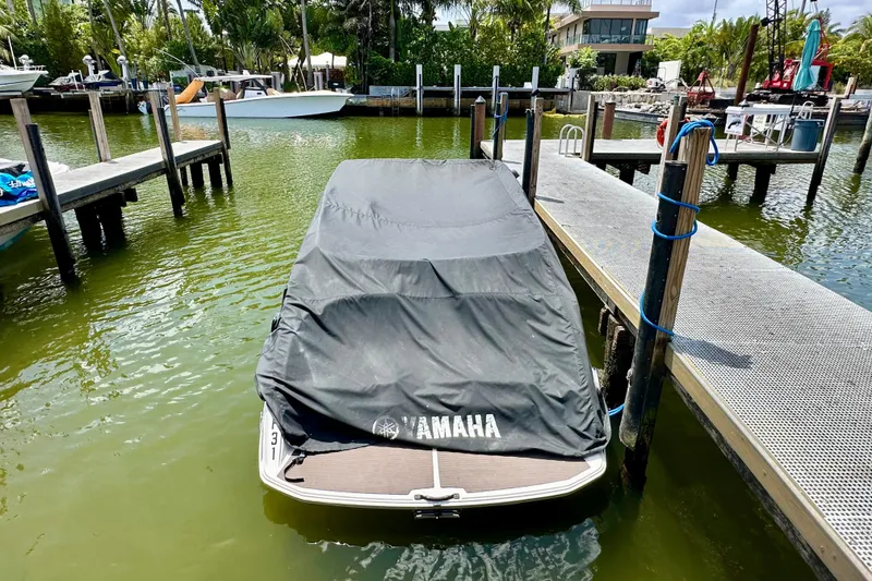 Slide: The Image of 2011 Yamaha Boats 242 Limited covered at dock, surrounded by calm water and greenery. - 30