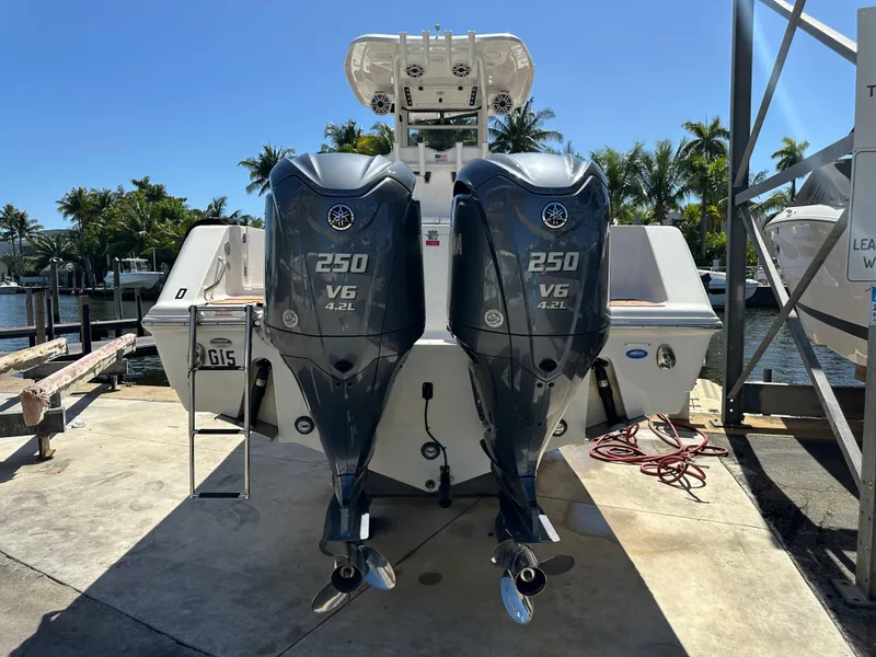 Slide: The Image of 2022 Tidewater 280 CC boat with dual Yamaha 250 V6 outboard engines, docked under sunny skies. - 2