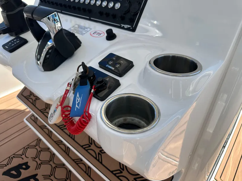 Slide: The Image of Control panel of 2022 Tidewater 280 CC boat with cup holders and keys. - 22