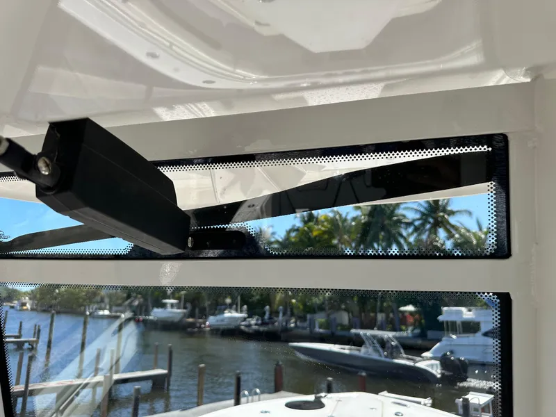 Slide: The Image of 2022 Tidewater 280 CC boat window view with marina and palm trees in the background. - 26