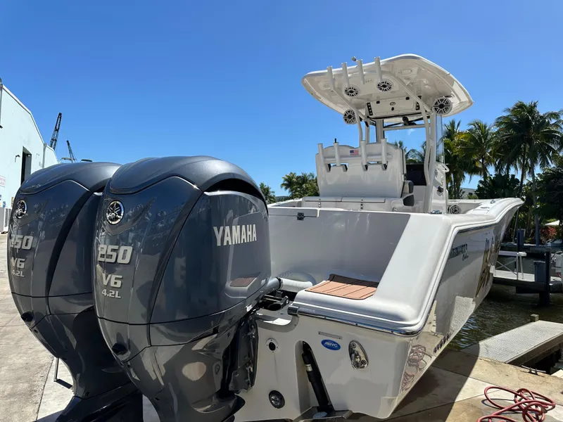 Slide: The Image of 2022 Tidewater 280 CC boat with dual Yamaha 250 V6 engines, docked under clear blue sky. - 3