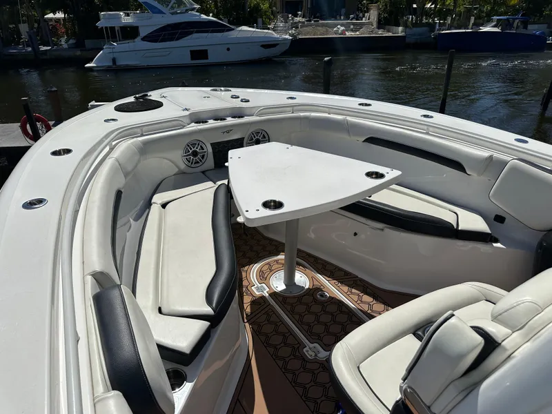Slide: The Image of 2022 Tidewater 280 CC boat interior with seating and table, docked by the water. - 34