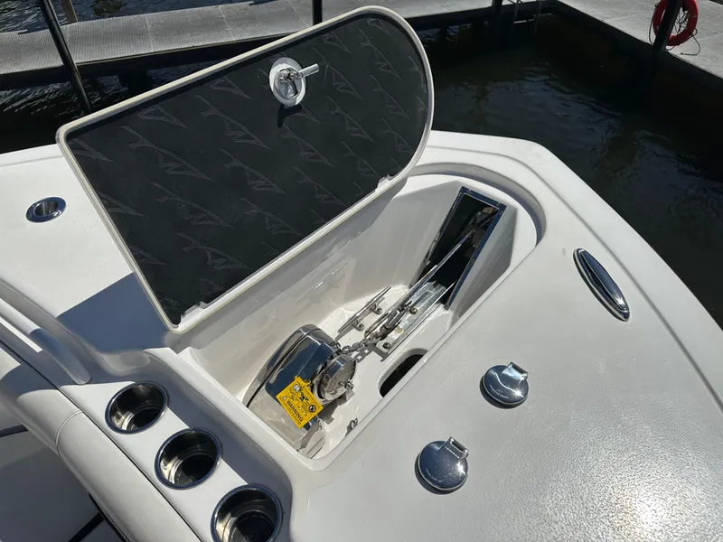 Slide: The Image of 2022 Tidewater 280 CC boat anchor compartment with open hatch and cup holders. - 36