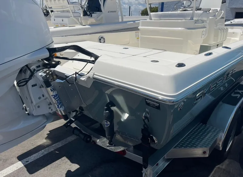 Slide: The Image of 2025 Skeeter SX230 boat on trailer, showcasing rear view and motor. - 2