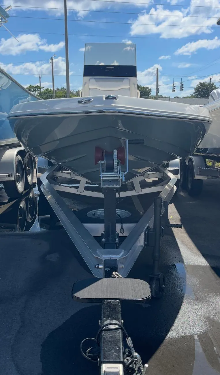 Slide: The Image of 2025 Skeeter SX230 boat on trailer under a clear blue sky. - 4