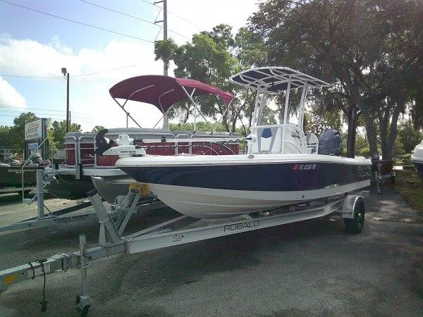 Slide: The Image of 2023 Robalo 206 Cayman boat on trailer, parked outdoors. - 1