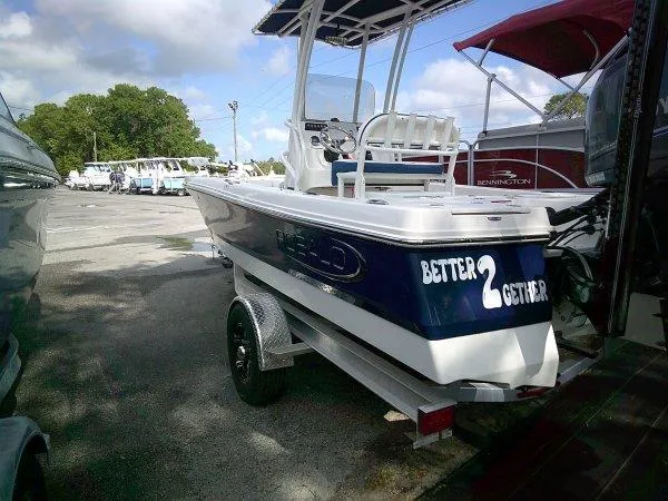 Slide: The Image of 2023 Robalo 206 Cayman boat on trailer, parked outdoors under cloudy sky. - 6