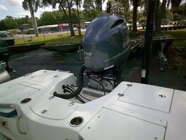 Slide: The Image of 2023 Robalo 206 Cayman boat with powerful outboard motor in a marina setting. - 7
