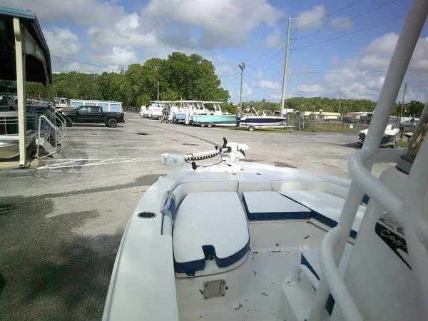 Slide: The Image of 2023 Robalo 206 Cayman boat parked in a marina under a partly cloudy sky. - 9