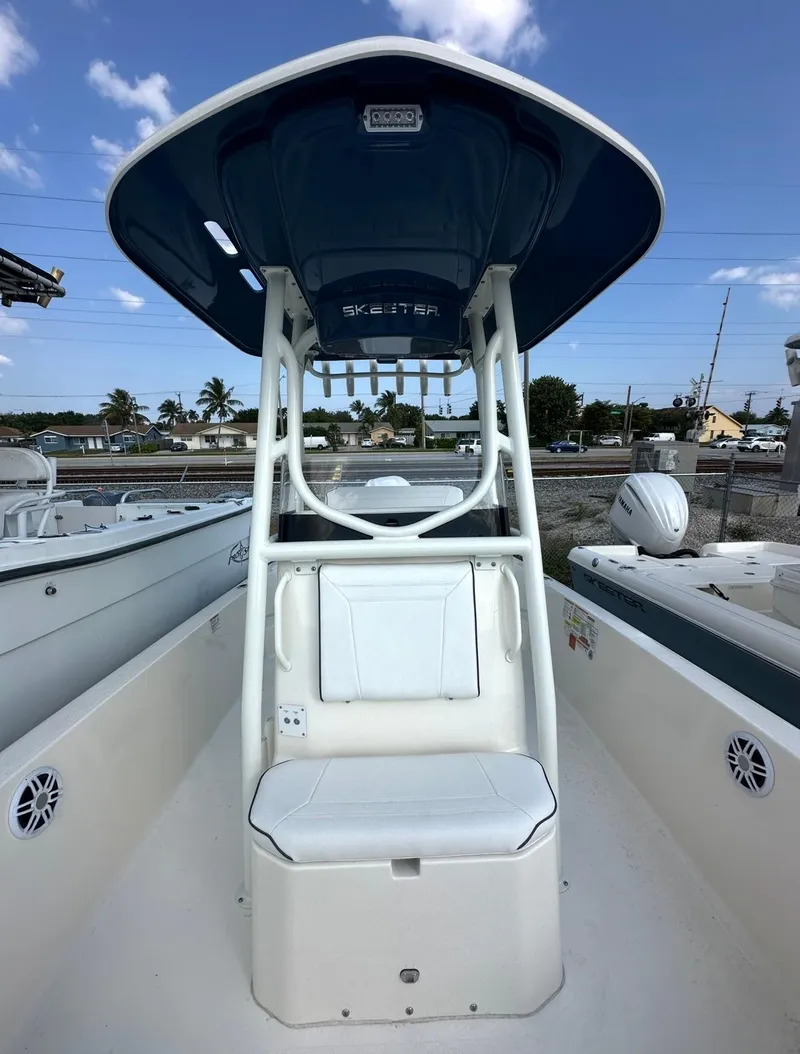 Slide: The Image of 2025 Skeeter SX 2350 boat with T-top and seating, docked under a clear blue sky. - 3