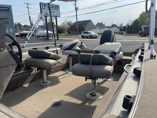 Slide: The Image of 2001 Tracker Pro Deep V 17 SC boat interior with seating and console, parked near a road. - 4