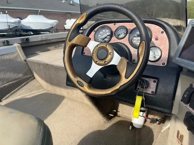 Slide: The Image of 2001 Tracker Pro Deep V 17 SC boat dashboard with steering wheel and gauges. - 7
