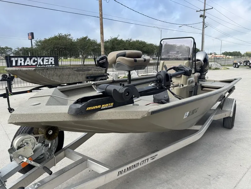 Slide: The Image of 2019 Alumacraft 18 Bay boat on trailer with Minn Kota motor, parked outdoors. - 10