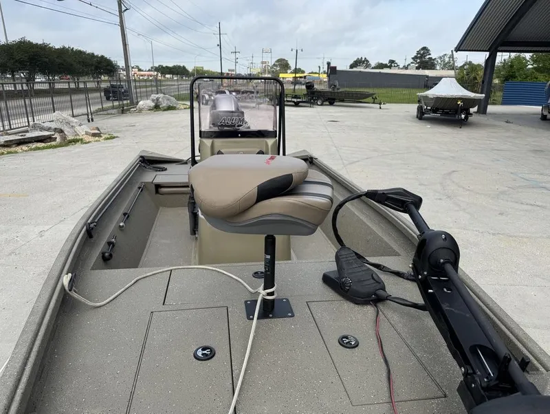 Slide: The Image of 2019 Alumacraft 18 Bay boat with seating and trolling motor in a parking area. - 13