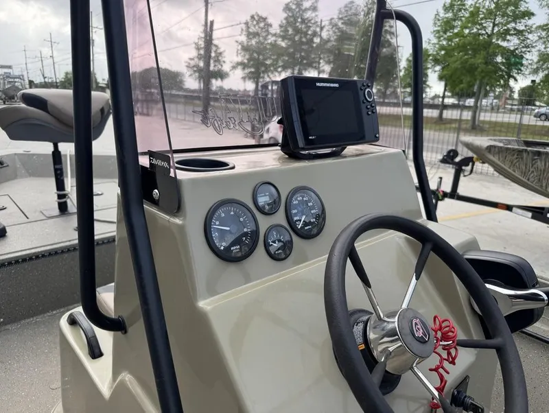 Slide: The Image of 2019 Alumacraft 18 Bay boat dashboard with steering wheel and navigation instruments. - 17