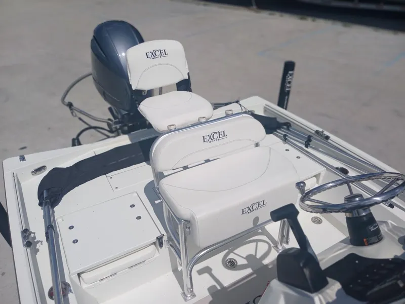 Slide: The Image of 2022 Excel 220 boat interior with steering wheel and seating, featuring branded upholstery. - 12