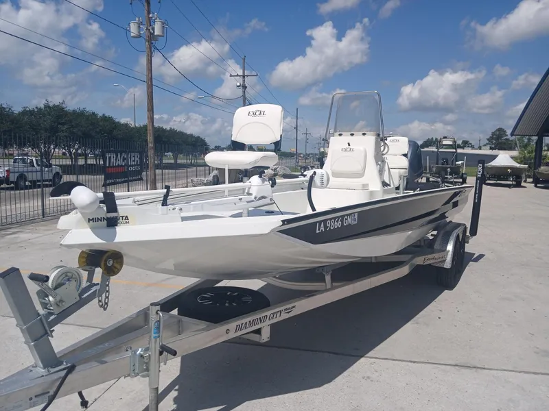 Slide: The Image of 2022 Excel 220 boat on trailer, parked outdoors under a clear blue sky. - 16