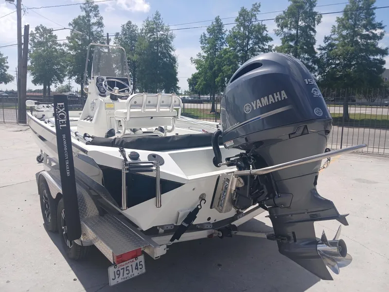 Slide: The Image of 2022 Excel 220 boat with Yamaha motor on trailer, parked outdoors. - 4