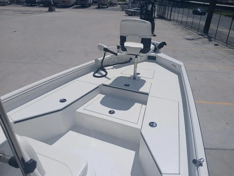 Slide: The Image of 2022 Excel 220 boat with white deck and seating, parked in a lot. - 6