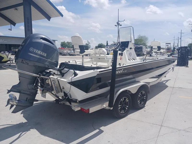 Slide: The Image of 2022 Excel 220 boat with Yamaha motor on trailer, parked outdoors. - 9