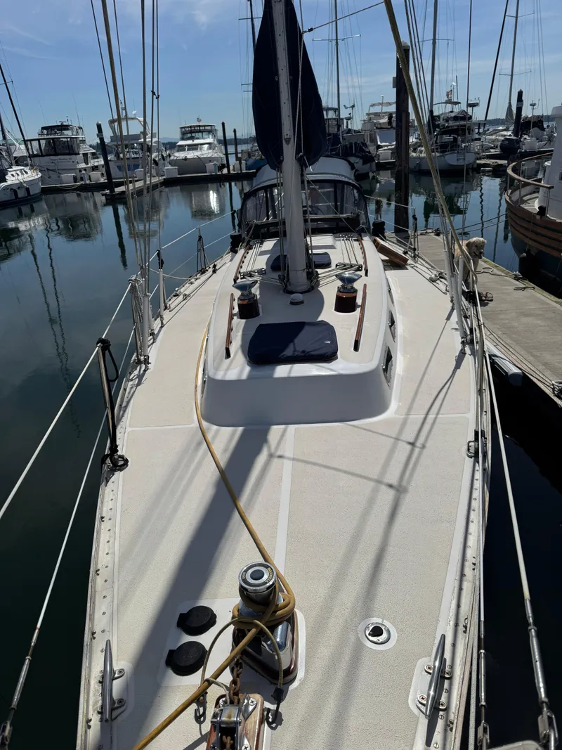Slide: The Image of 1984 Ohlson 38 sailboat docked in a marina, surrounded by other boats. - 16