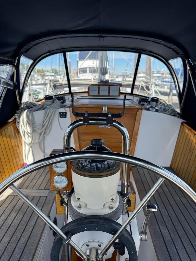 Slide: The Image of 1984 Ohlson 38 sailboat cockpit with steering wheel, gauges, and wooden interior. - 20