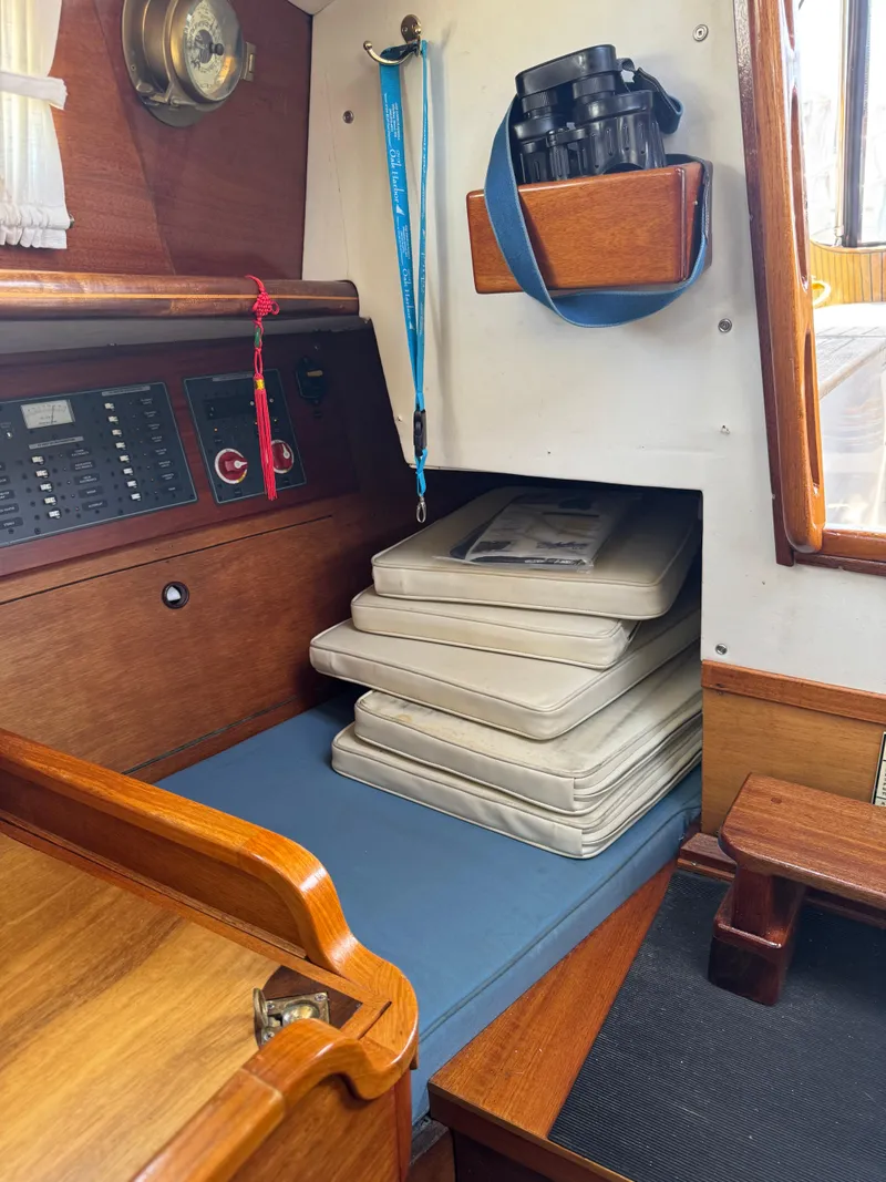 Slide: The Image of Interior of 1984 Ohlson 38 sailboat with stacked cushions and navigation equipment. - 23