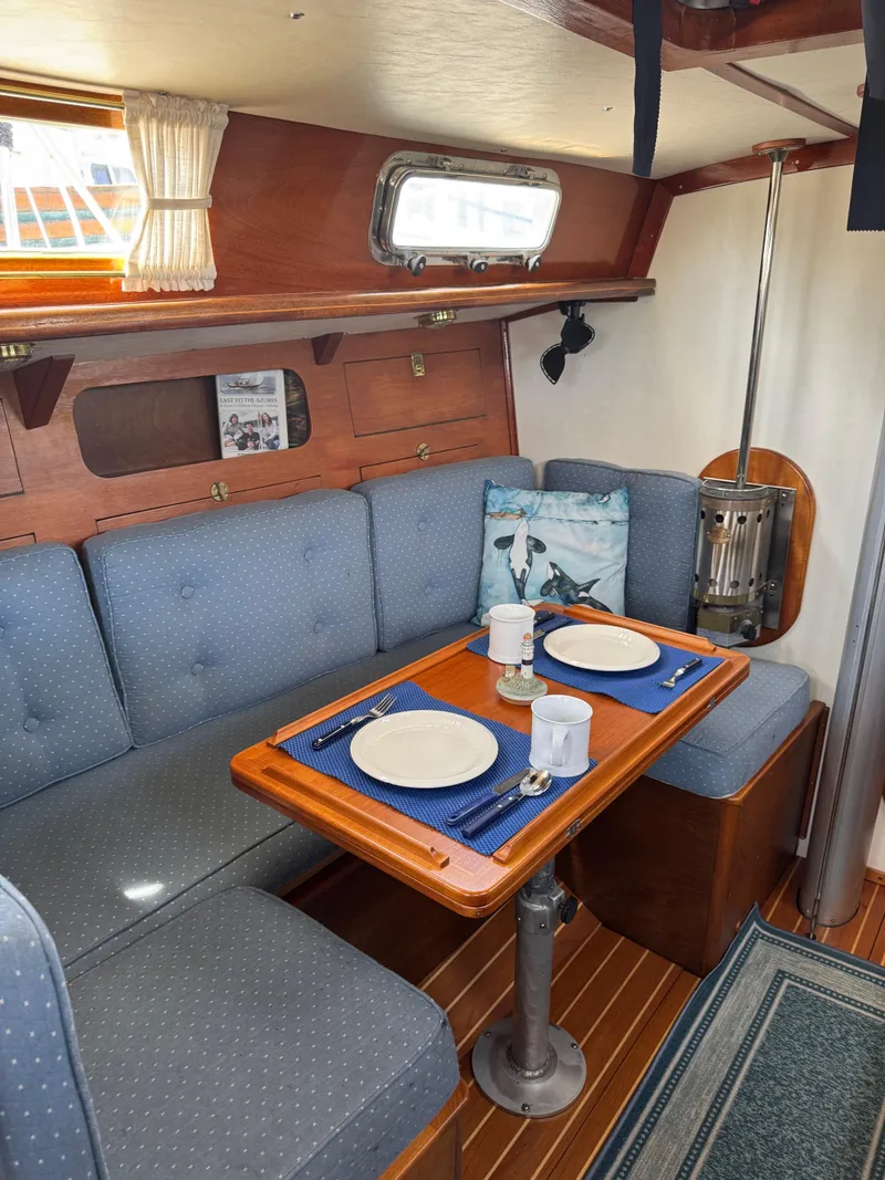 Slide: The Image of Cozy interior of 1984 Ohlson 38 sailboat with dining area and nautical decor. - 28